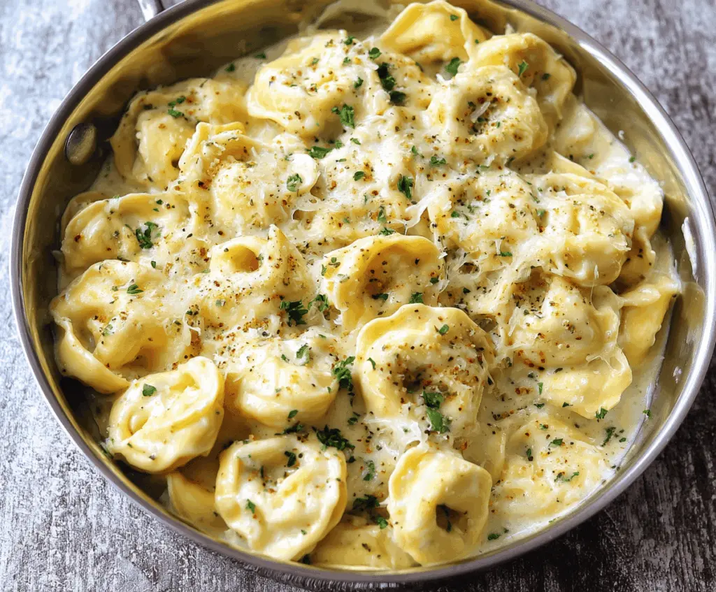 Creamy cheesy Alfredo tortellini dish garnished with fresh herbs, perfect for a comforting Italian meal.