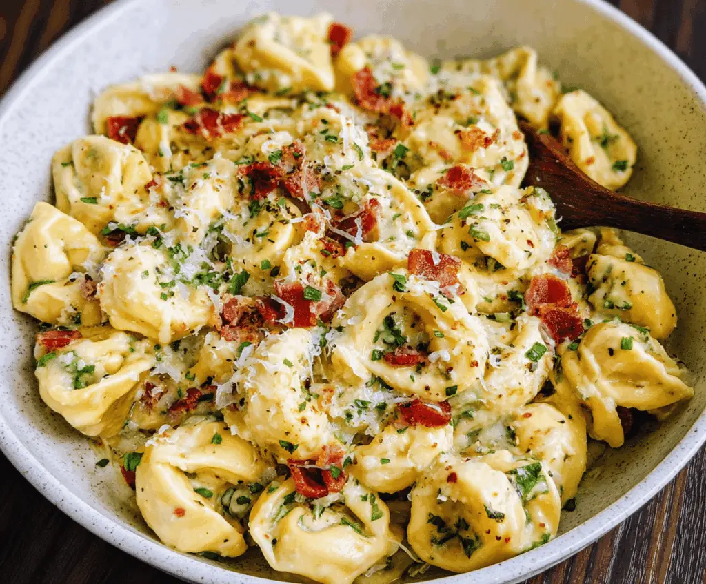 Creamy tortellini carbonara served in a bowl topped with grated Parmesan cheese and fresh herbs, delicious Italian pasta dish