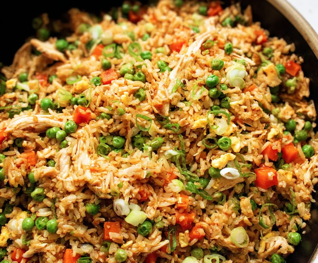 Delicious rotisserie chicken fried rice with colorful vegetables and savory seasonings.